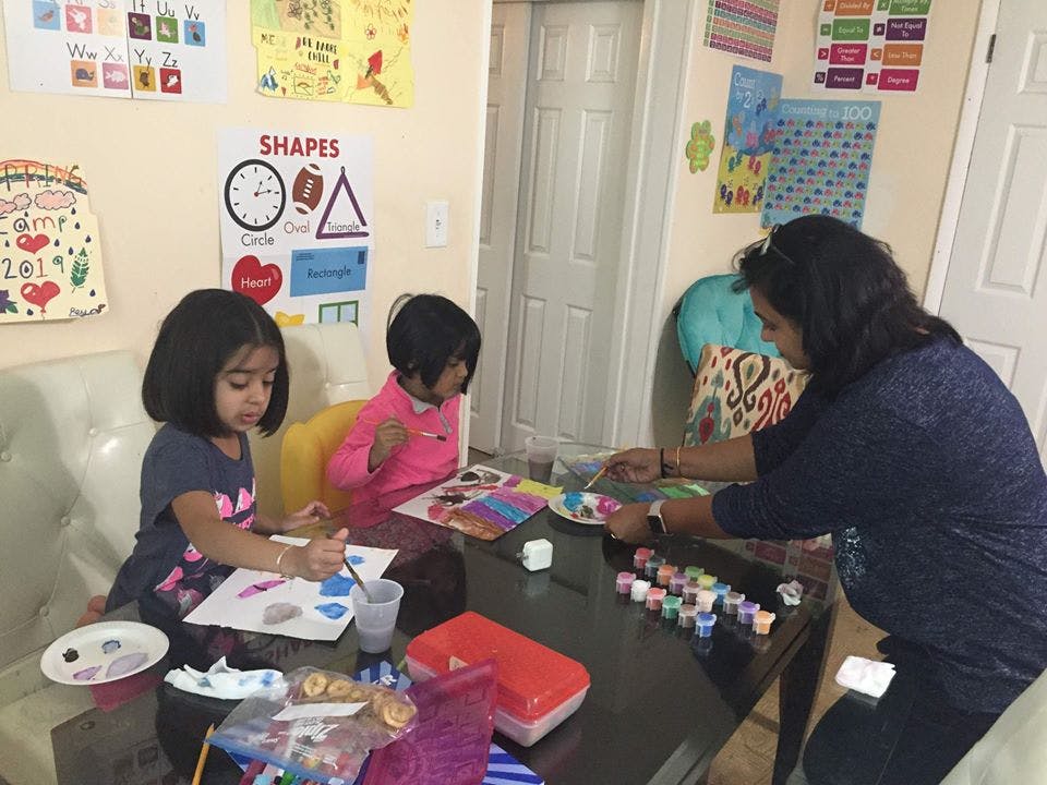 Adult and two children painting at a table