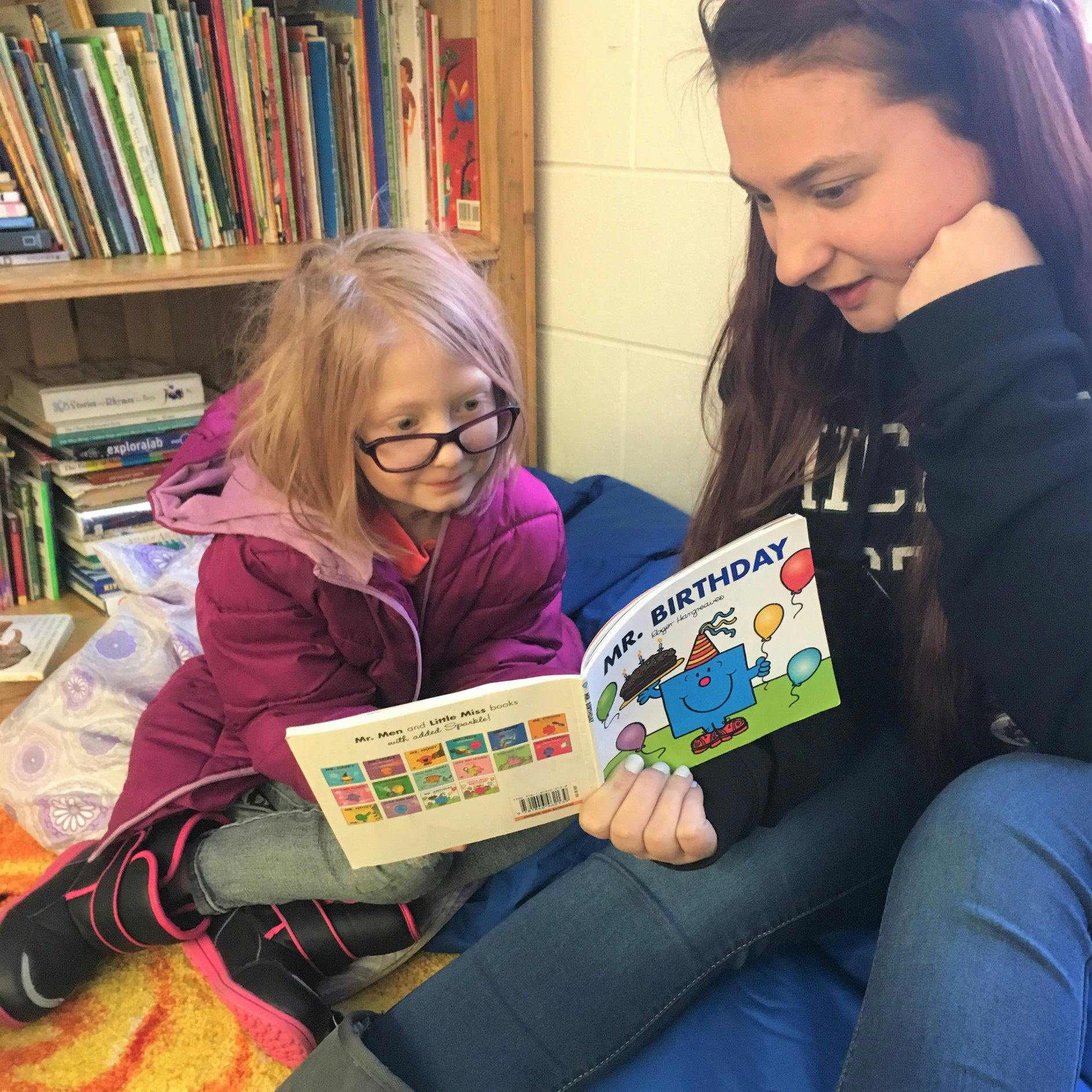 Person and child reading a book together