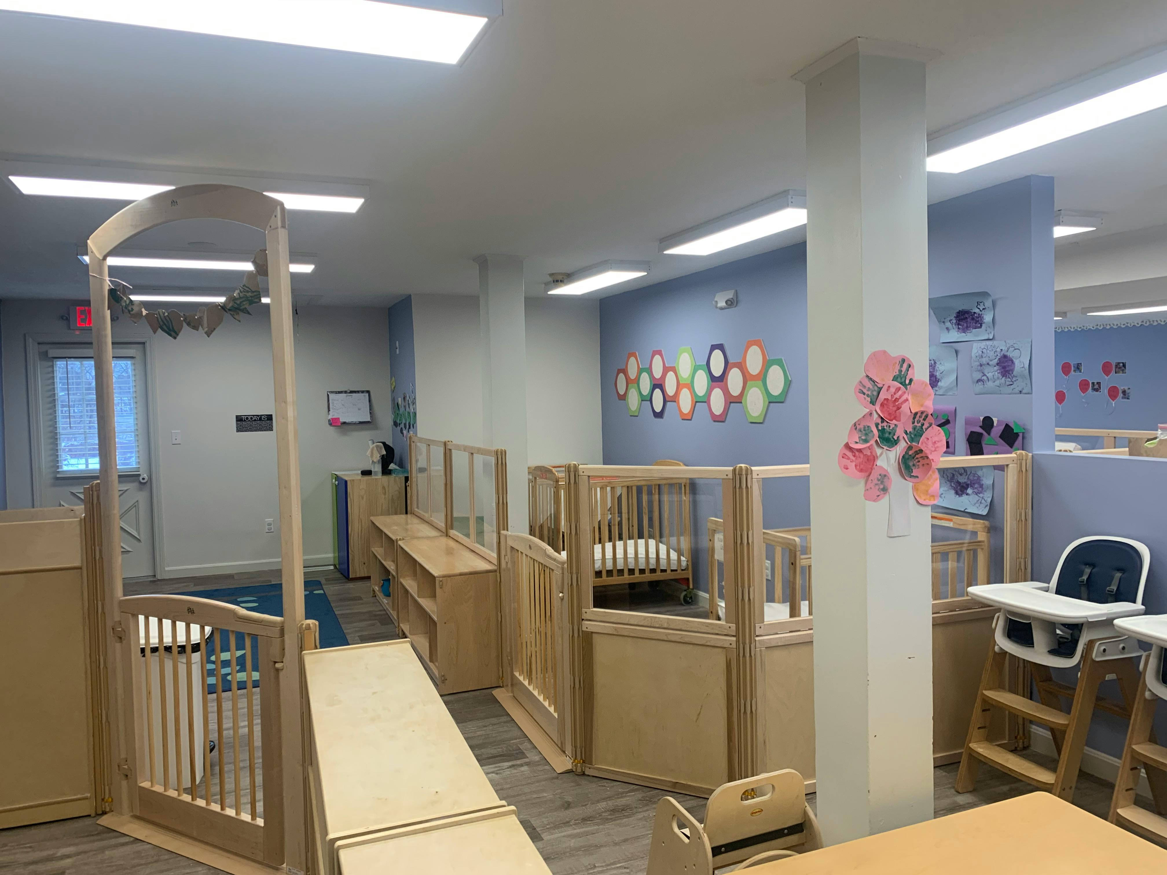 Nursery room with multiple wooden cribs and high chairs