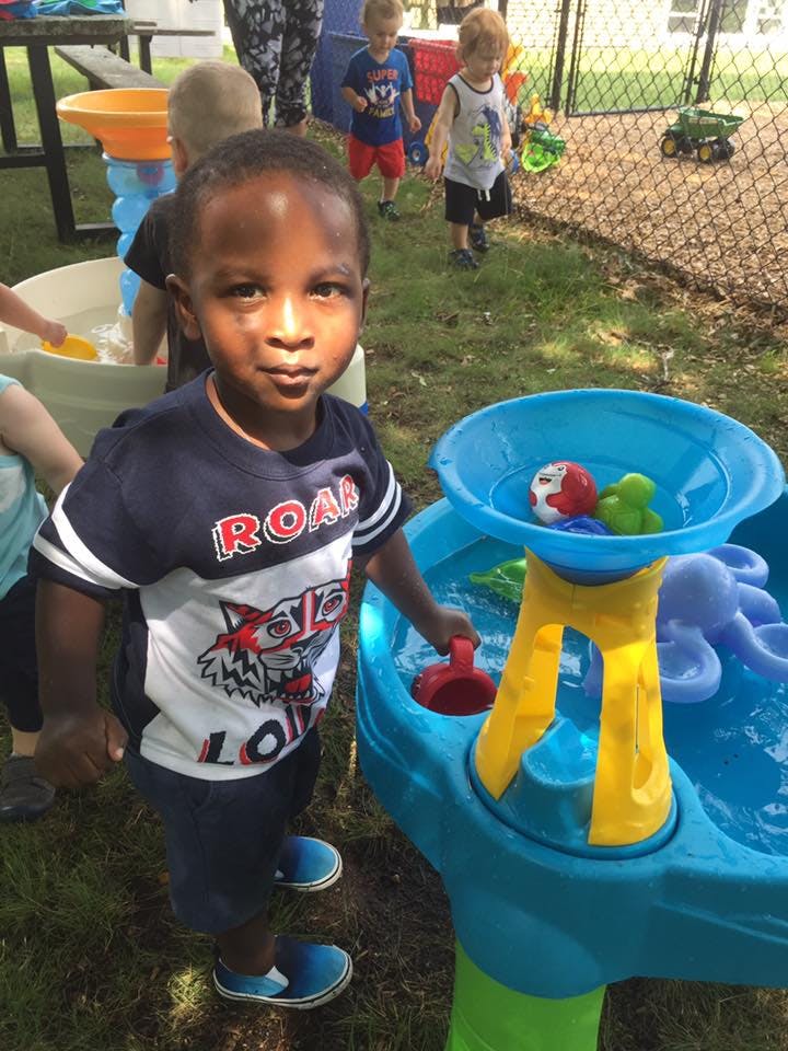 Child playing with a water table outdoors