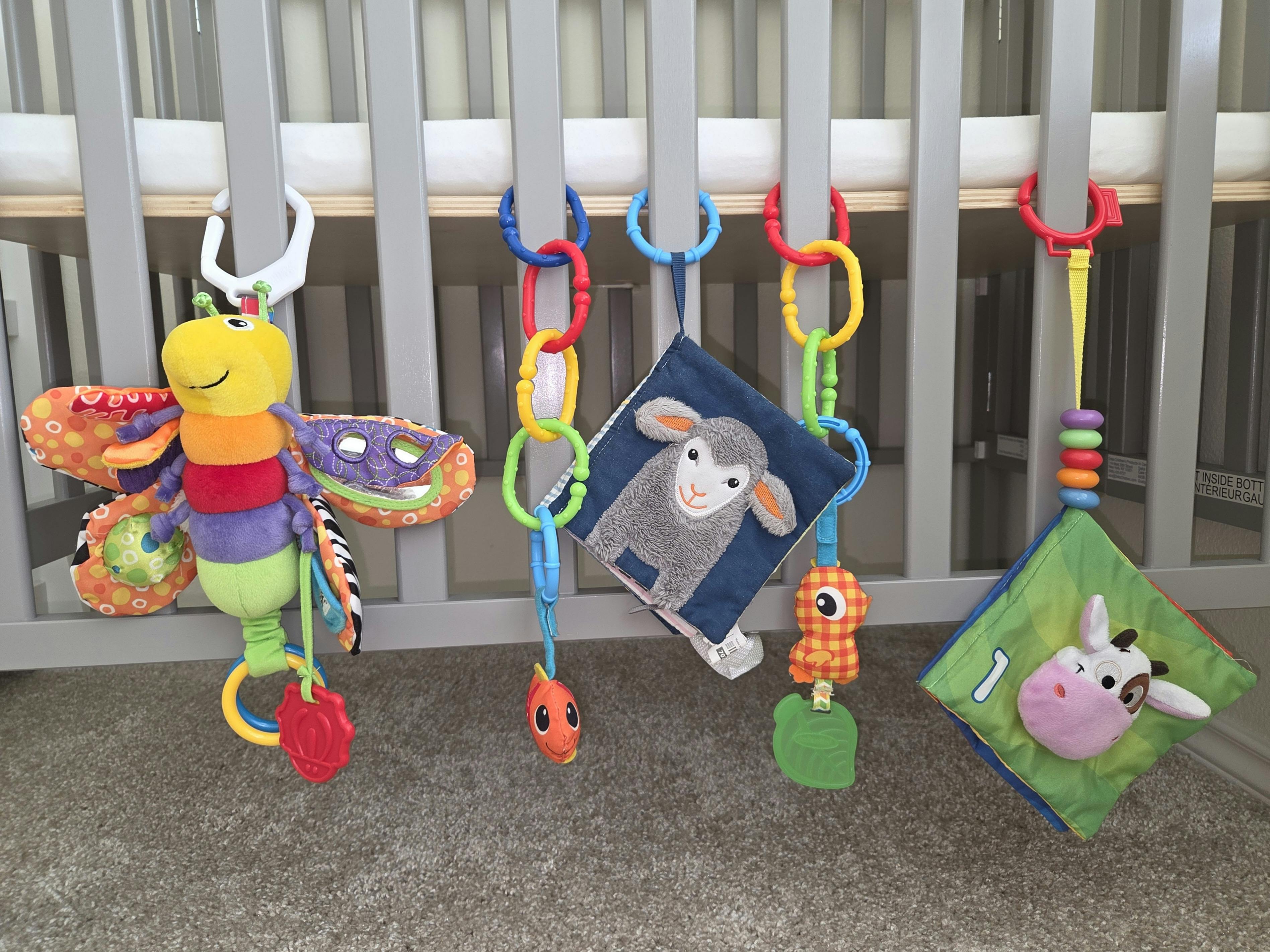 Baby toys hanging from a crib railing
