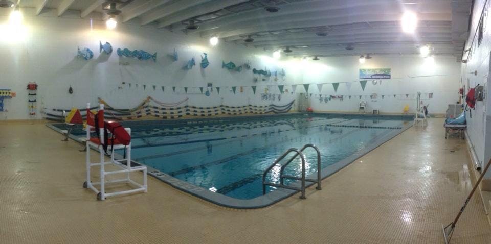 Indoor swimming pool with lane lines and a lifeguard chair