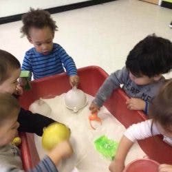 Children playing in a sand table with toys