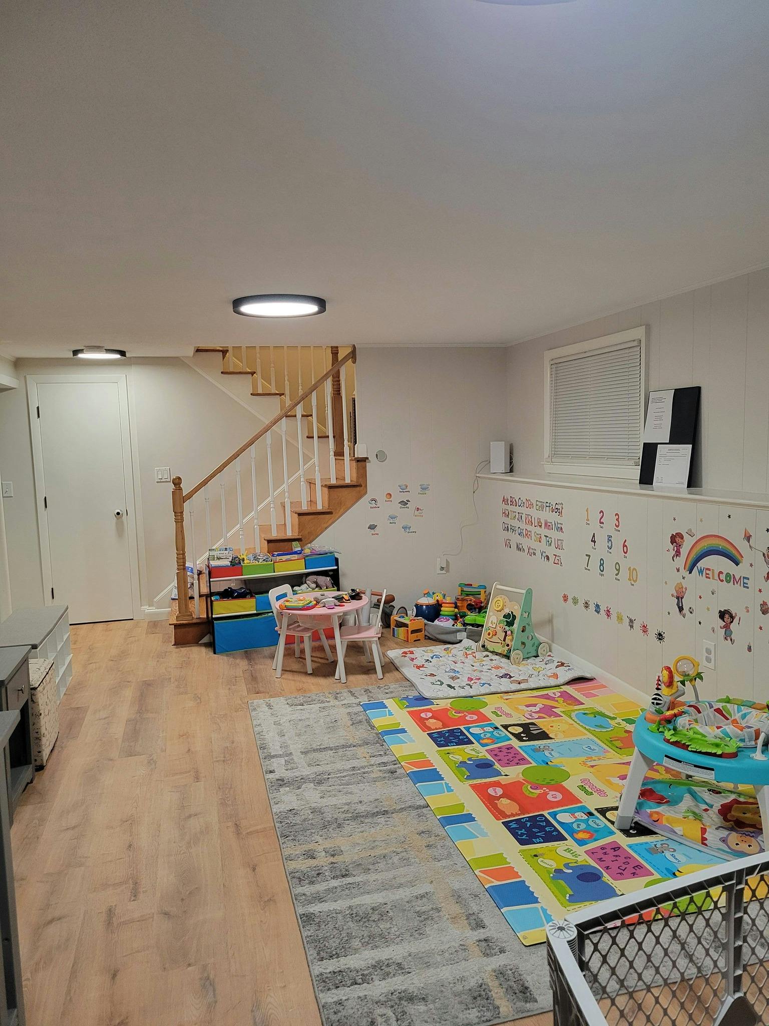Playroom with a staircase, colorful play mats, and child-sized furniture
