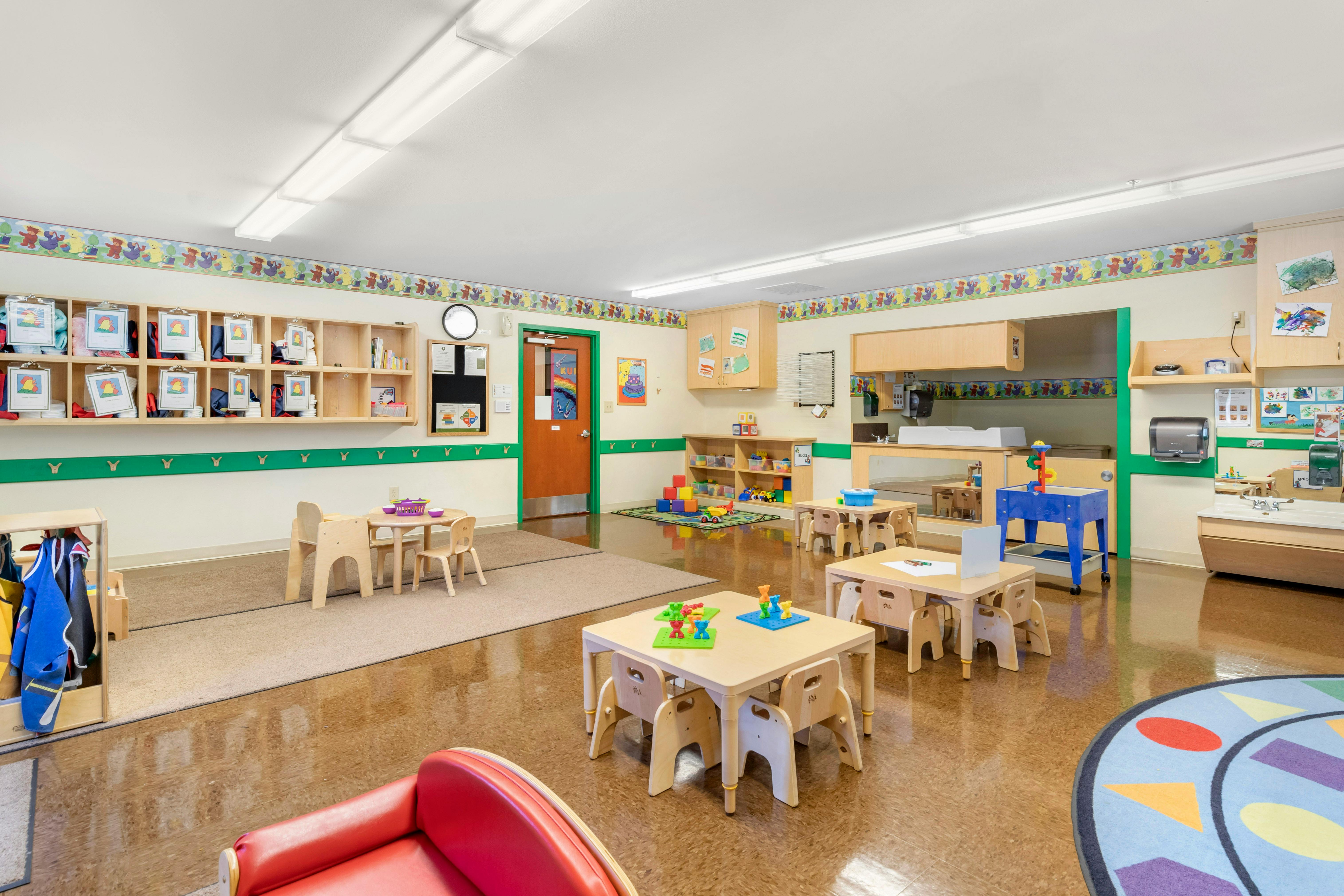 Empty colorful children's classroom with small tables and chairs