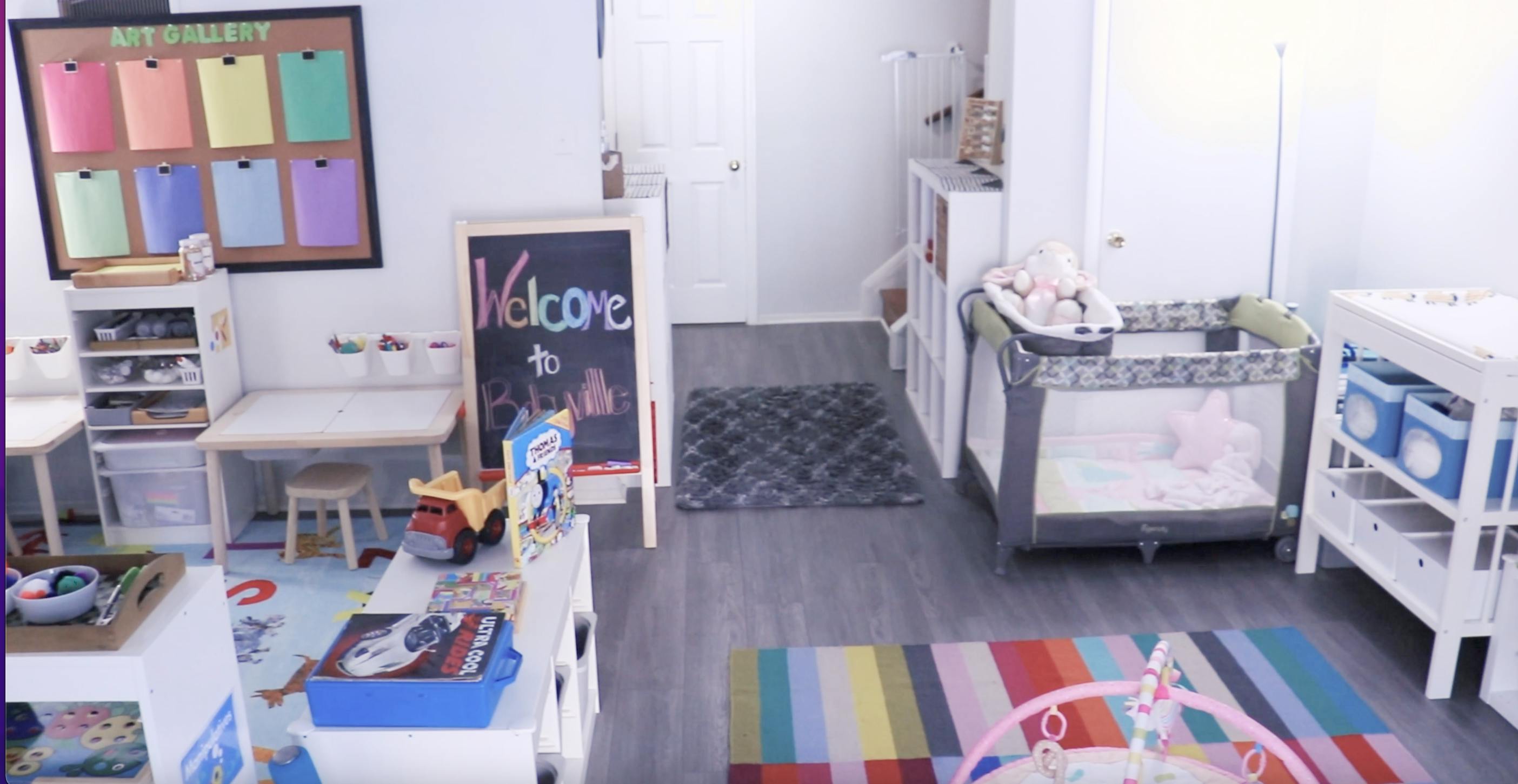 Playroom with crib, changing table, and chalkboard with "Welcome" written on it