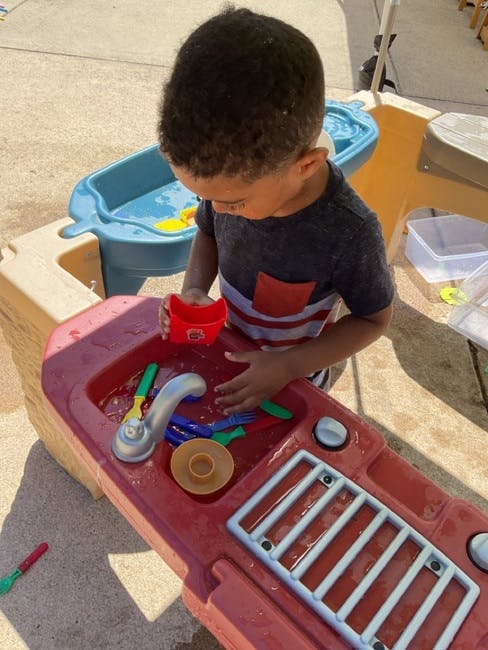 Child playing with a water table
