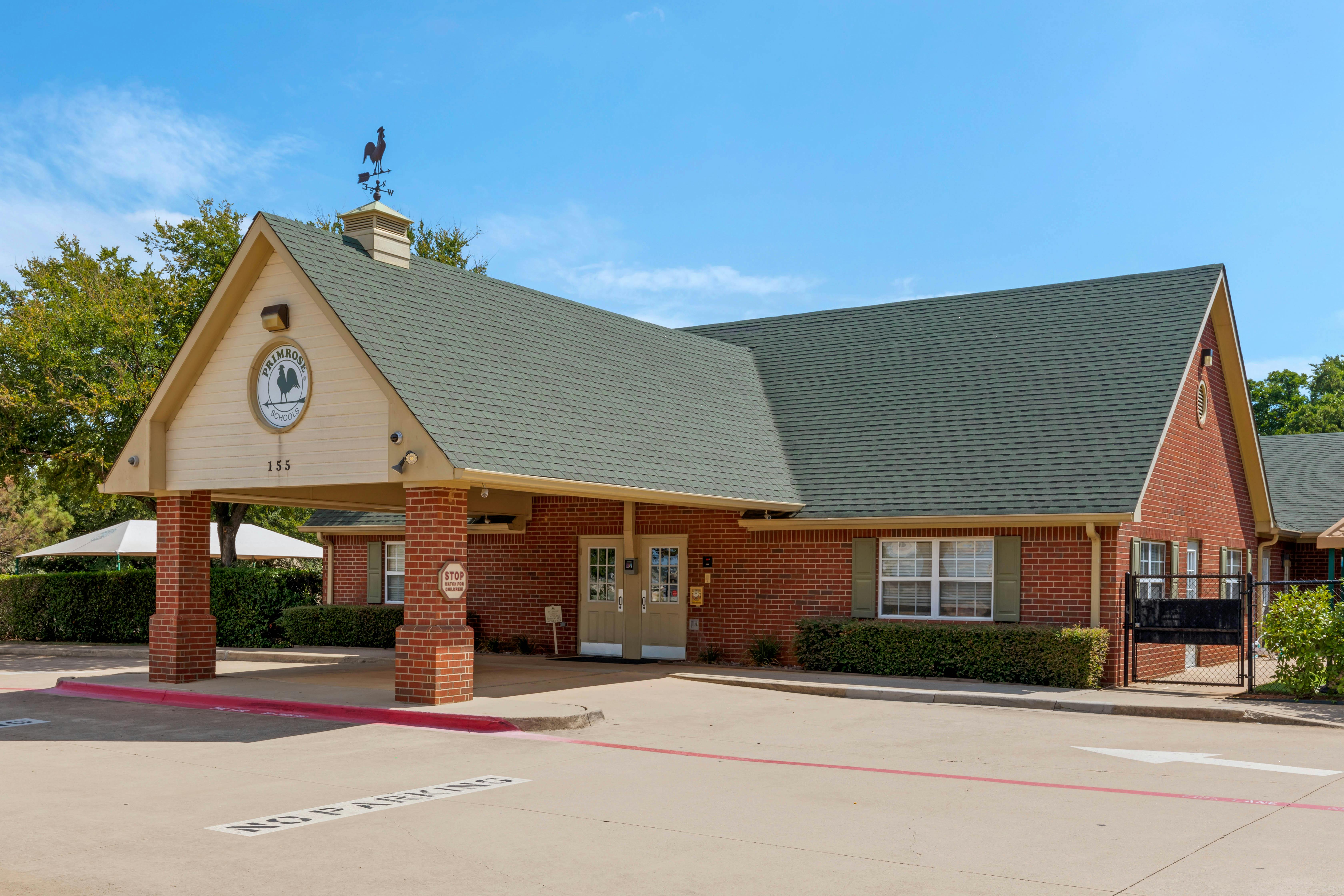 Brick building with a green roof, drive-through portico, and a weather vane