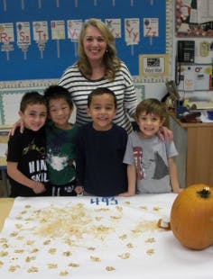 Adult and four children in a classroom