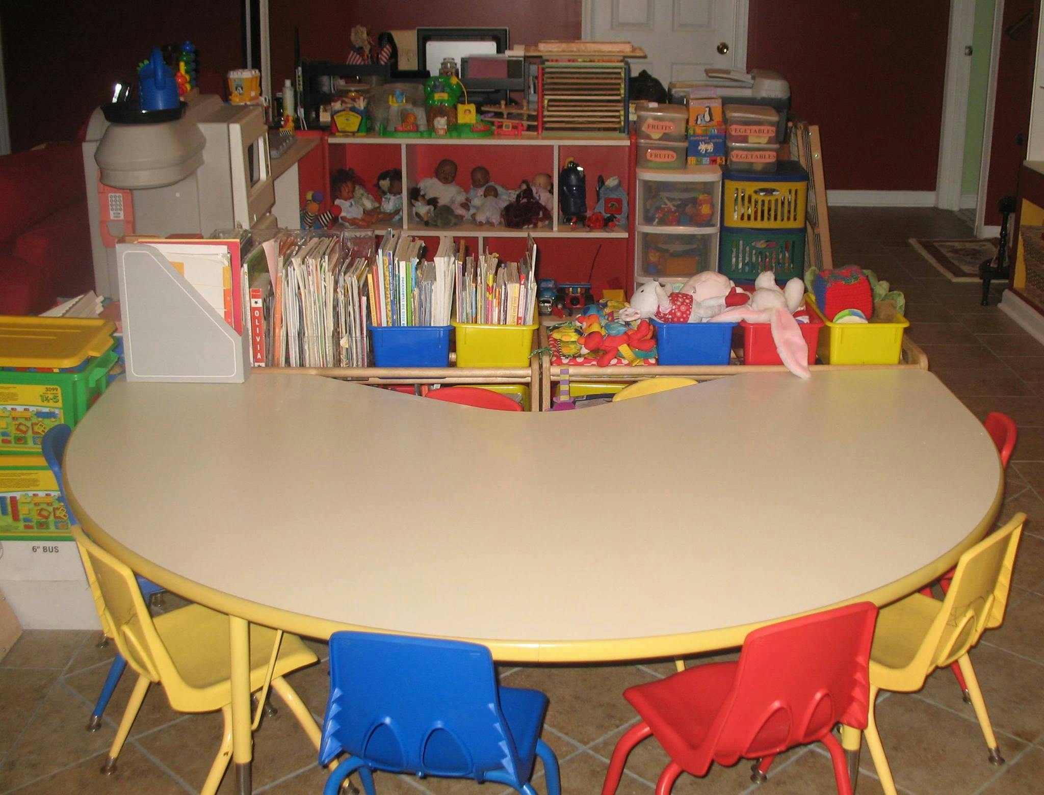 Kidney-shaped table with colorful chairs in a classroom