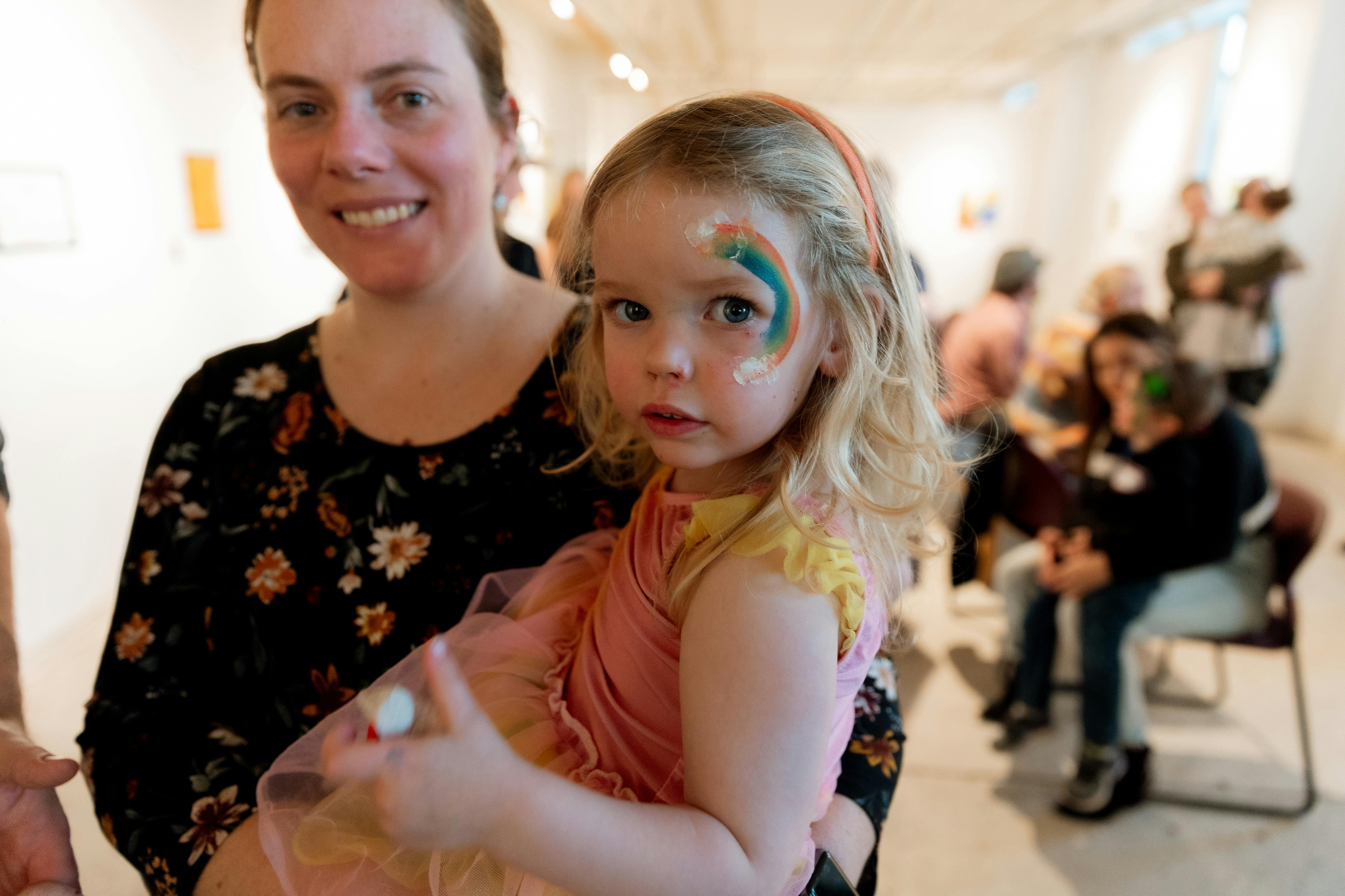 Person holding a child with face paint