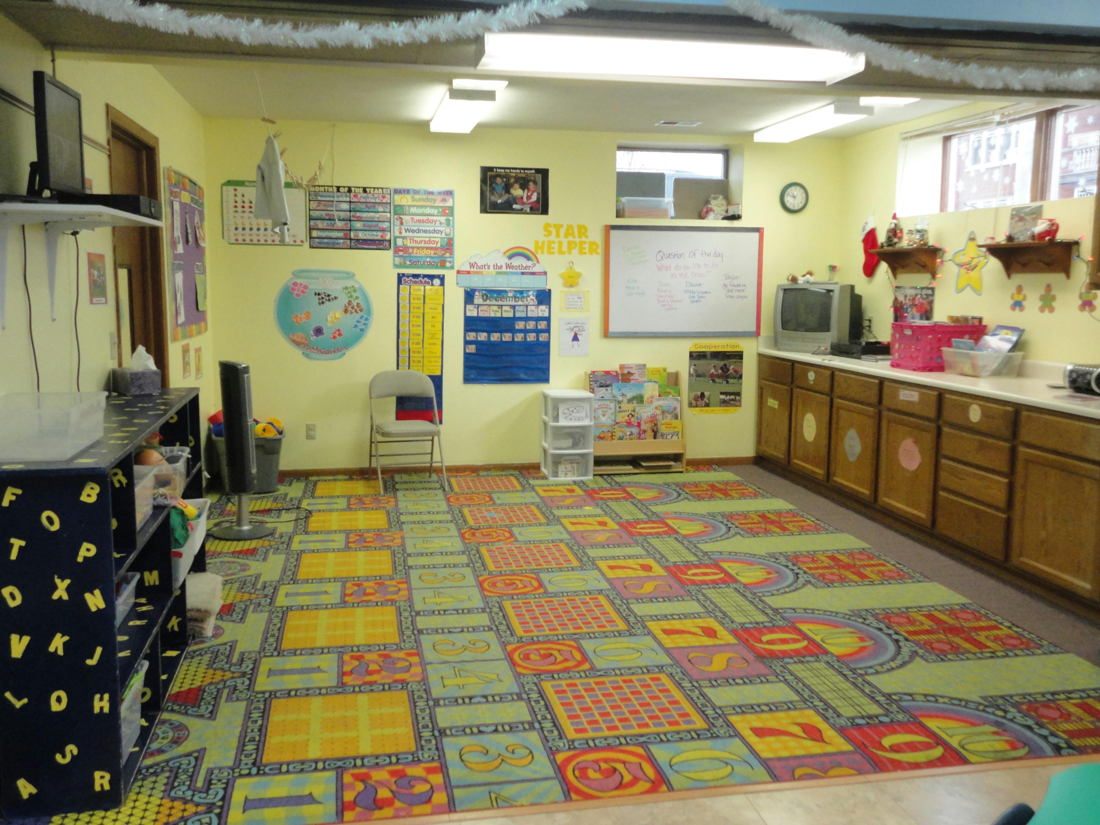 Classroom with colorful alphabet rug and whiteboards