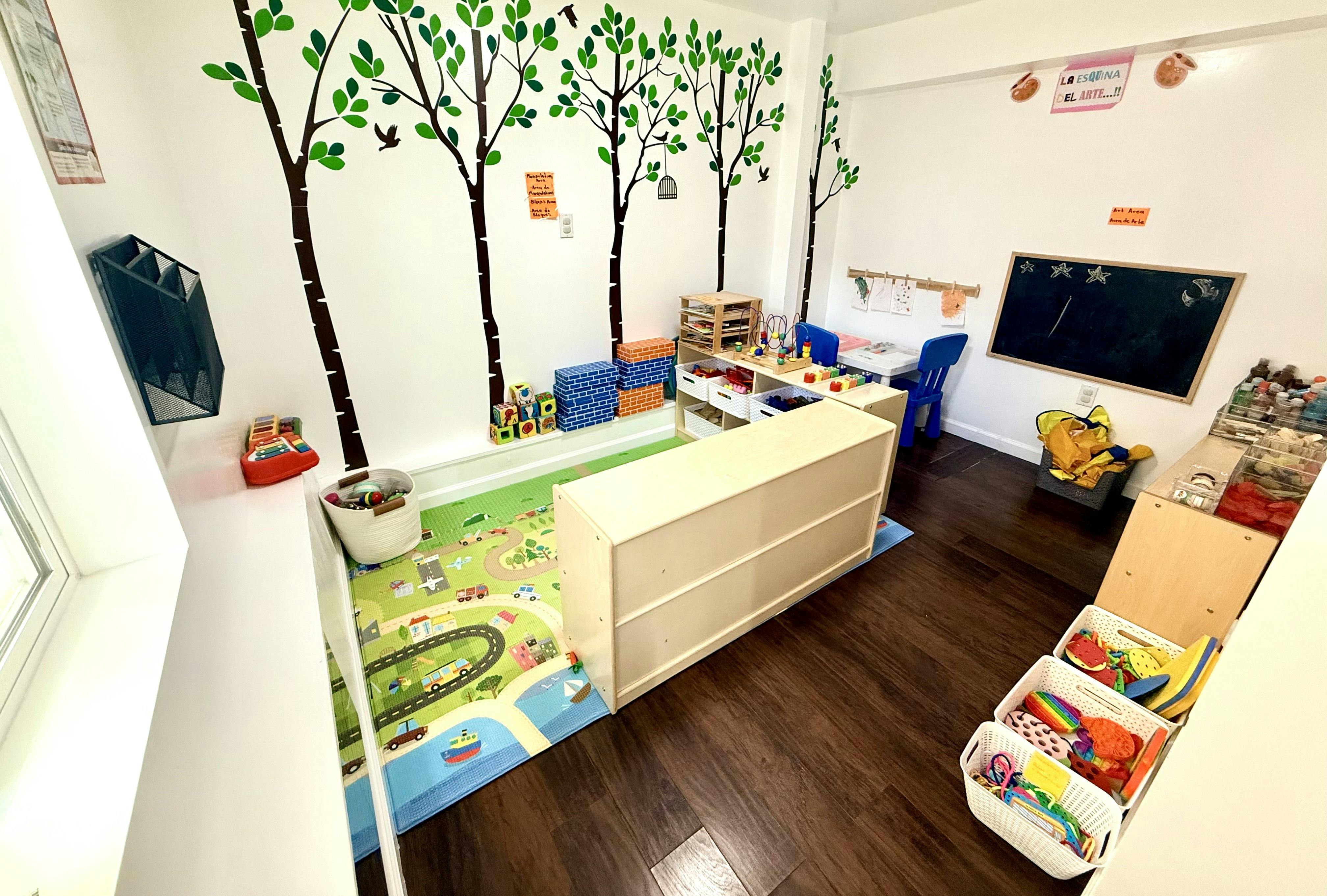 Childcare room with play mat, storage shelves, and wall art