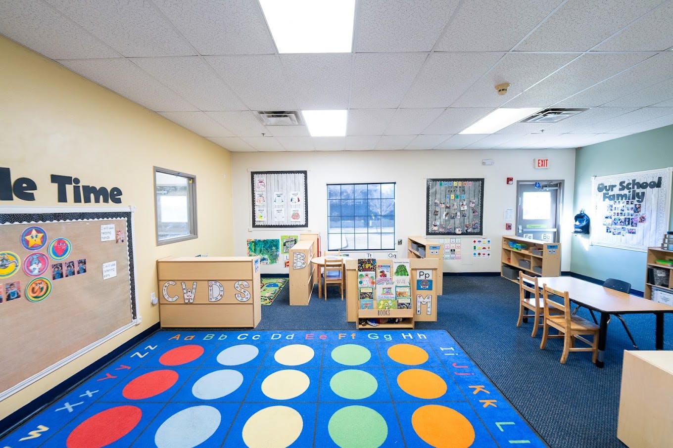 Empty preschool classroom with alphabet rug and learning stations