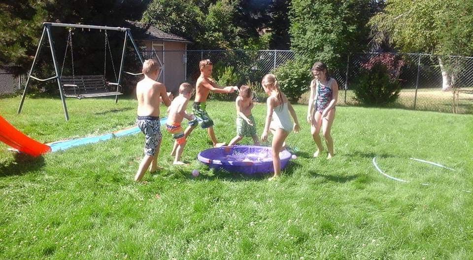 Children playing with water in a backyard