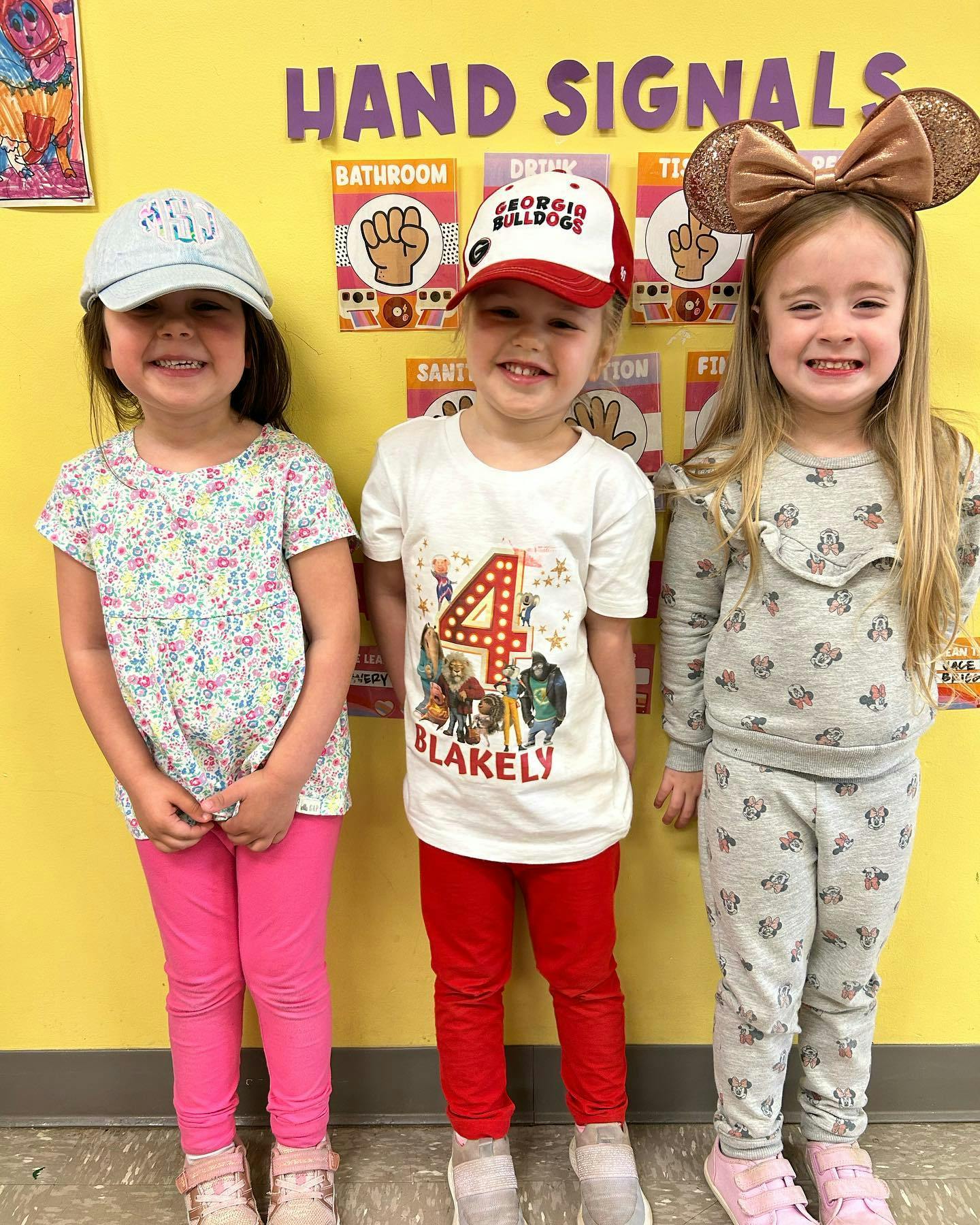 Three children standing in a row, smiling