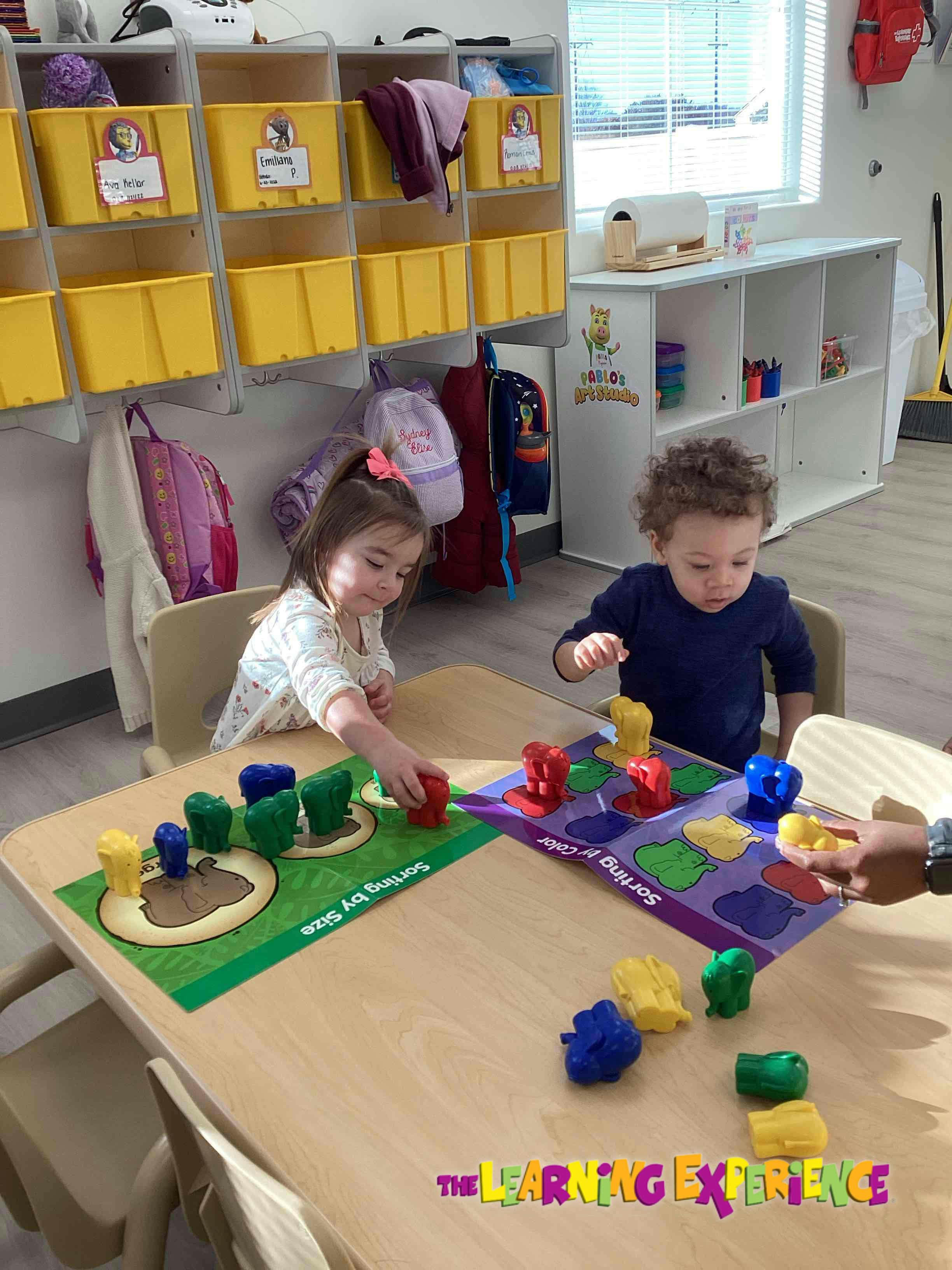 Two children playing with sorting toys at a table