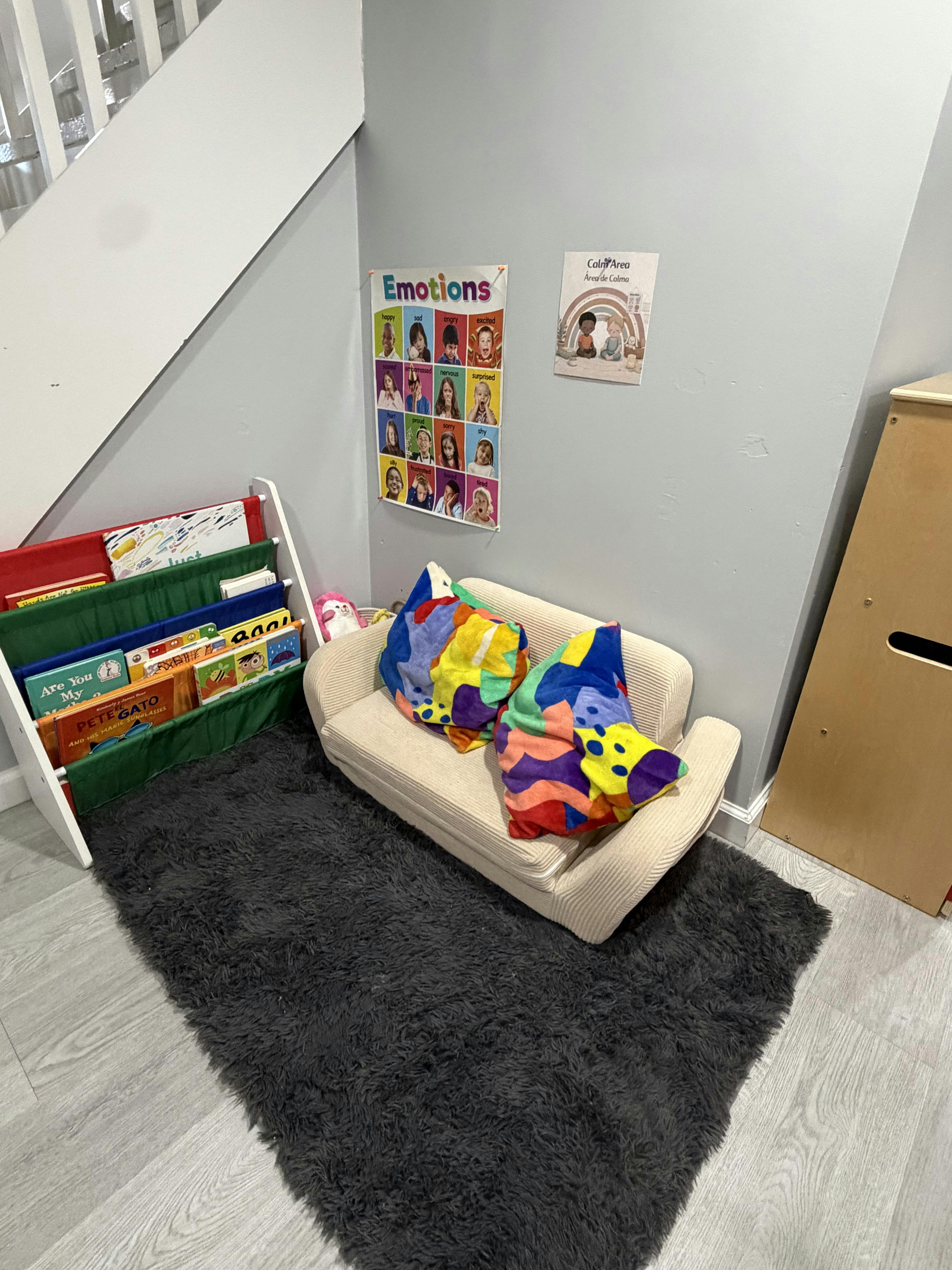 Small couch with cushions and a book rack in a child calm area