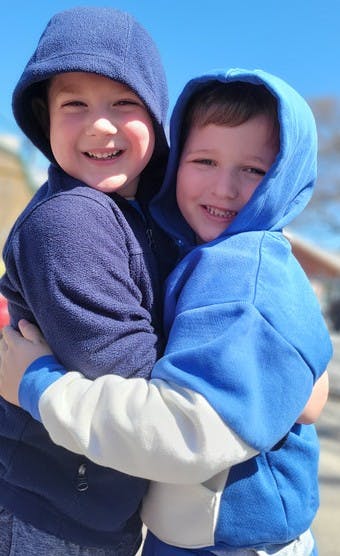 Two children in hoodies hugging