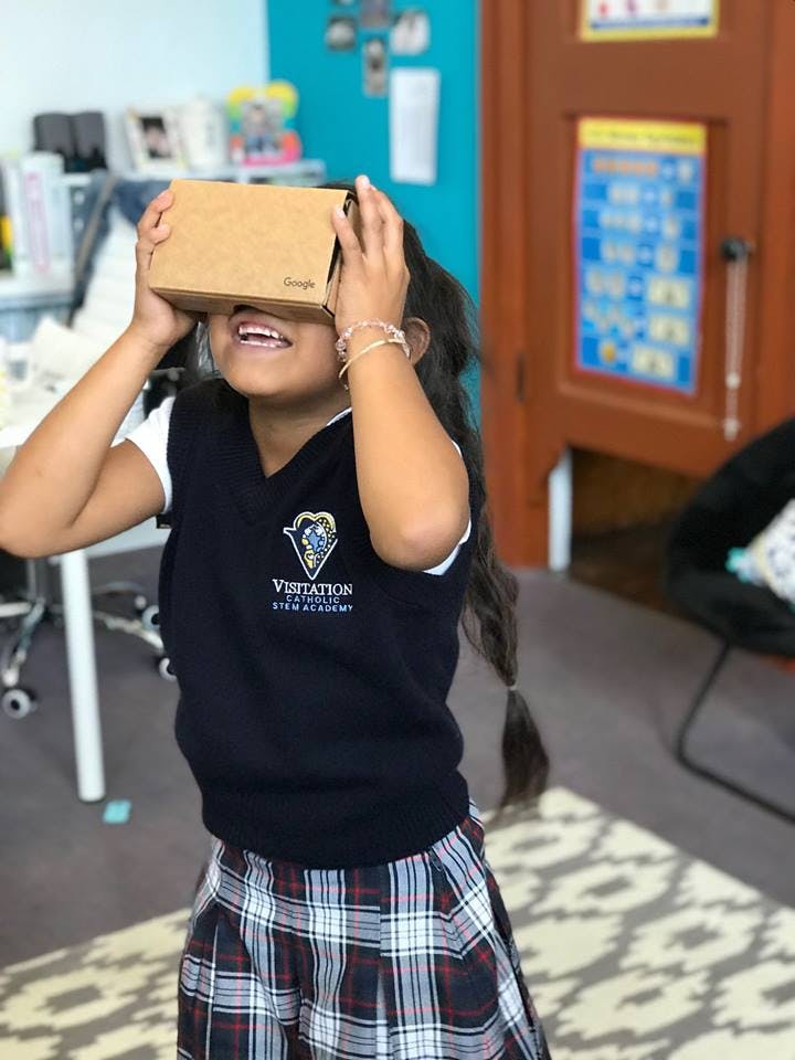 Child looking through a cardboard virtual reality viewer