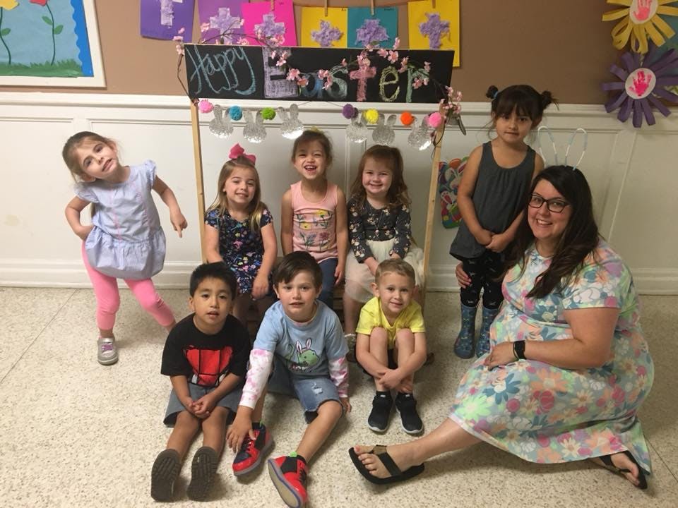 Adult and multiple children posing for a photo indoors