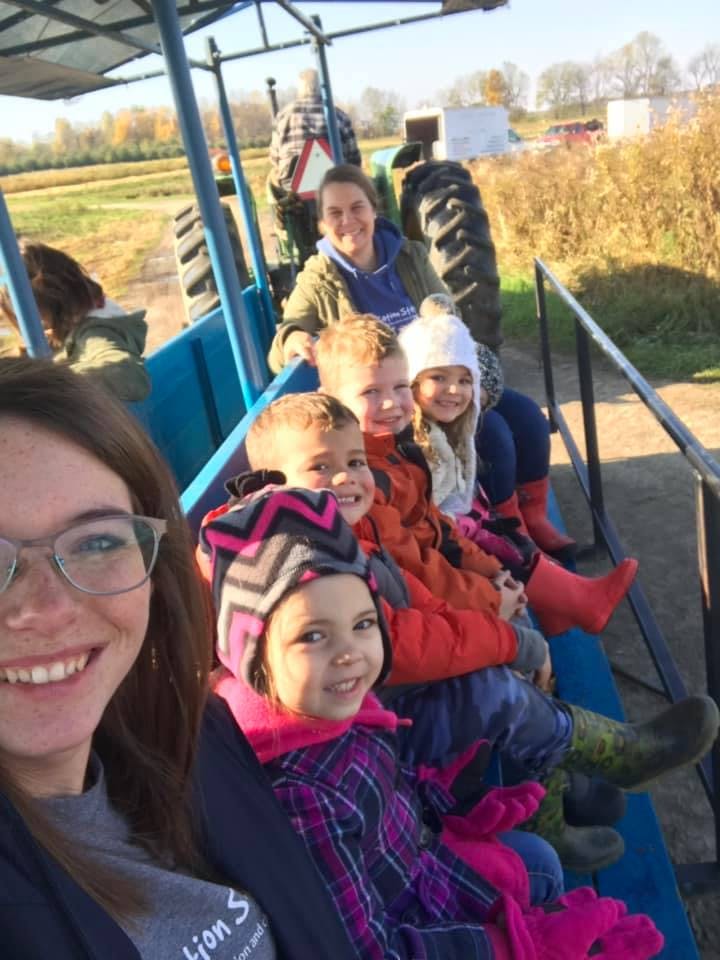 People and children riding on a tractor-pulled wagon