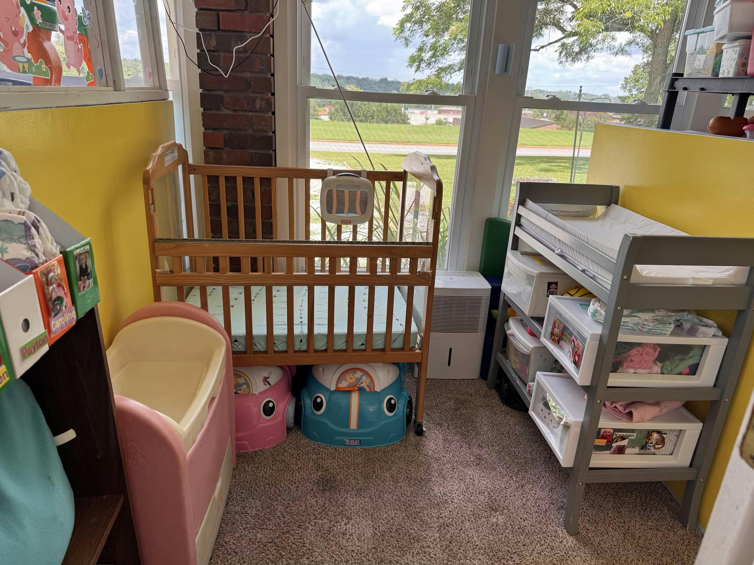 Nursery room with a wooden crib and a changing table with storage
