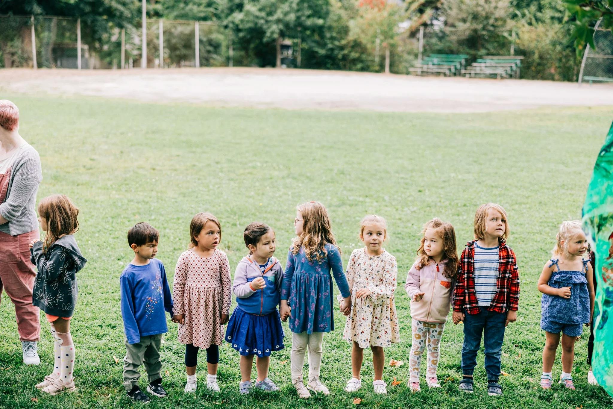 Children lined up outdoors on grass