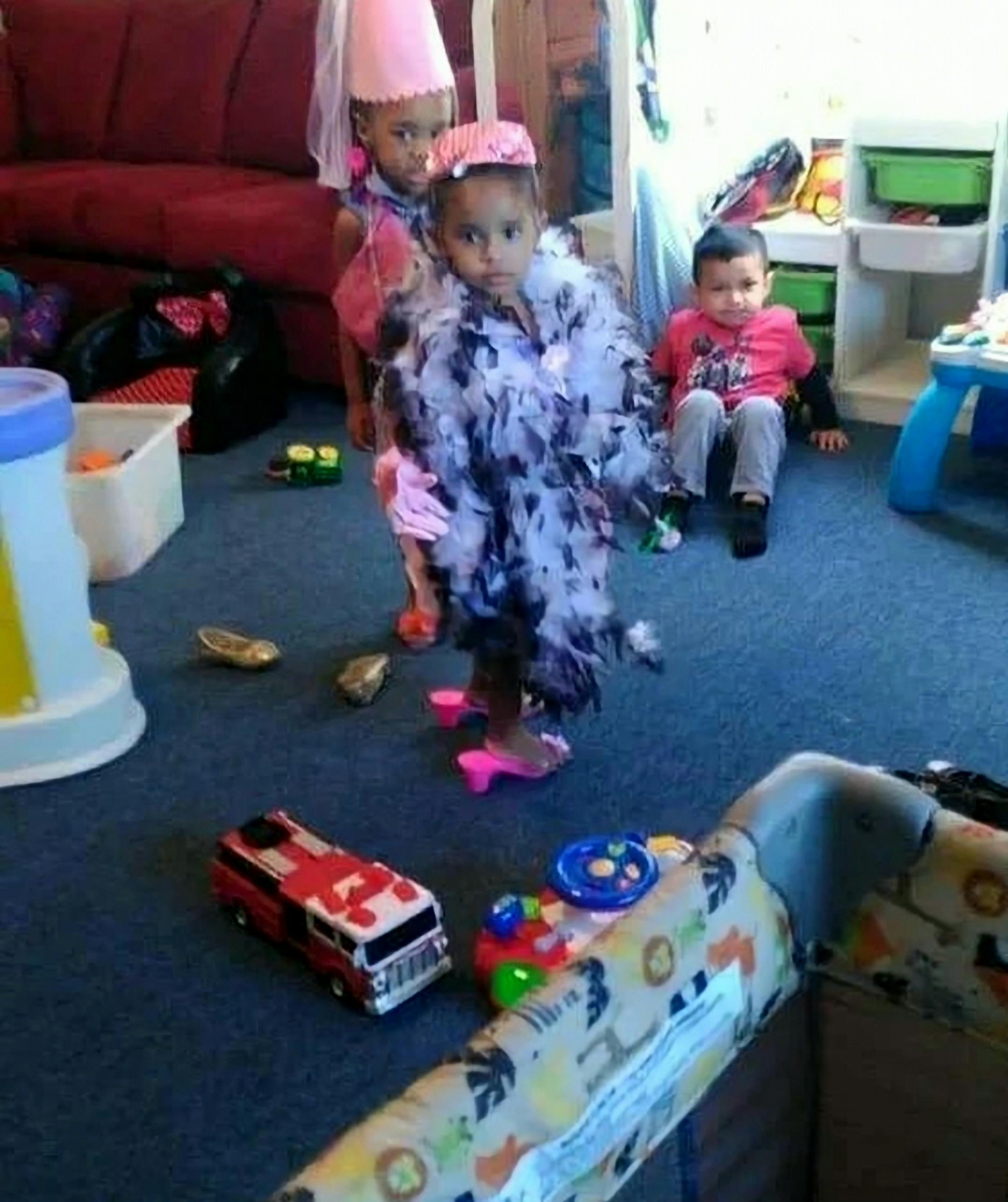 Three children playing dress-up in a room