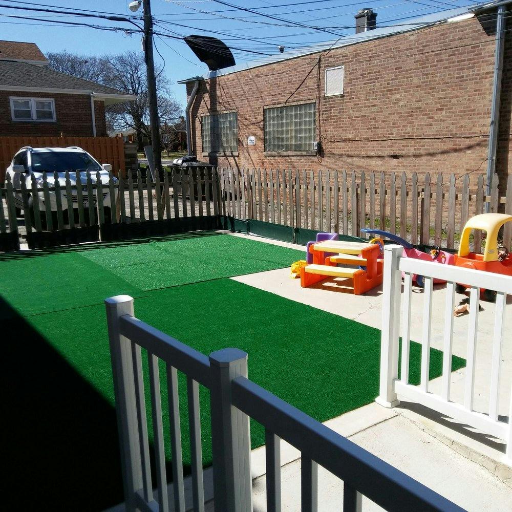 Backyard with artificial turf, concrete patio, and children's play furniture
