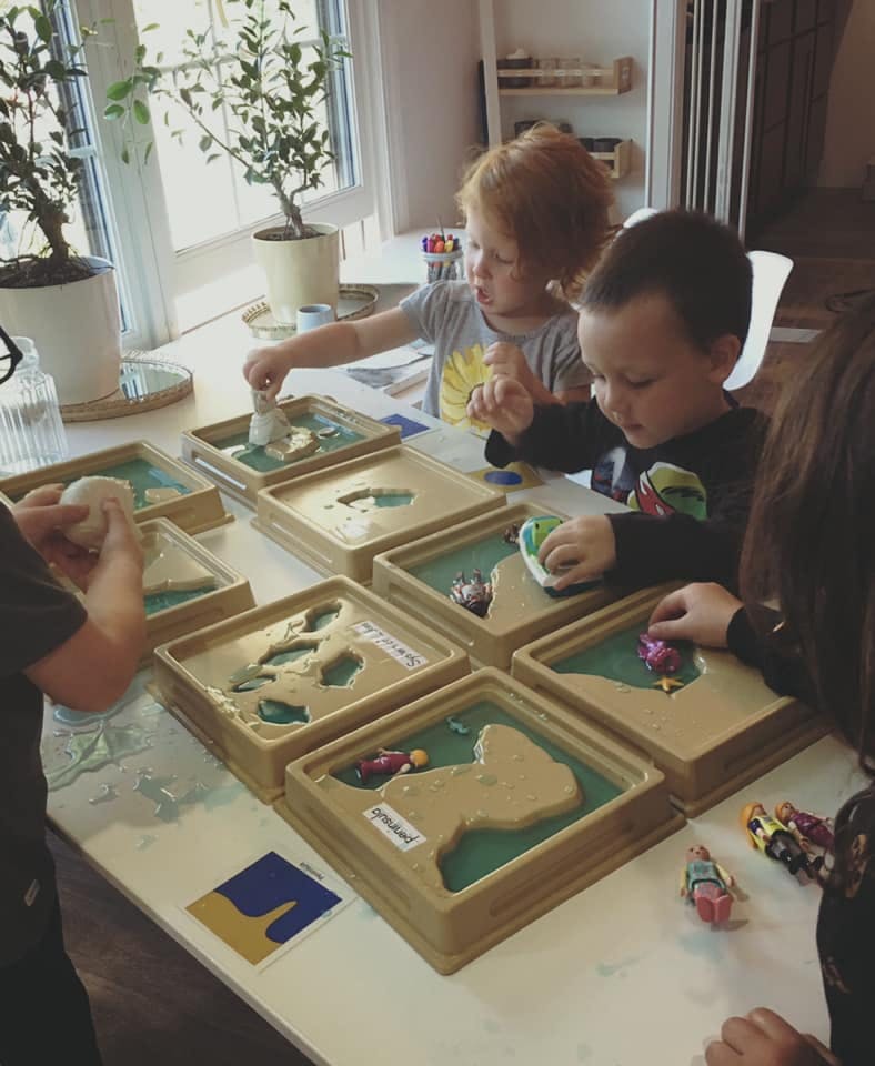 Children playing with sand and water in trays