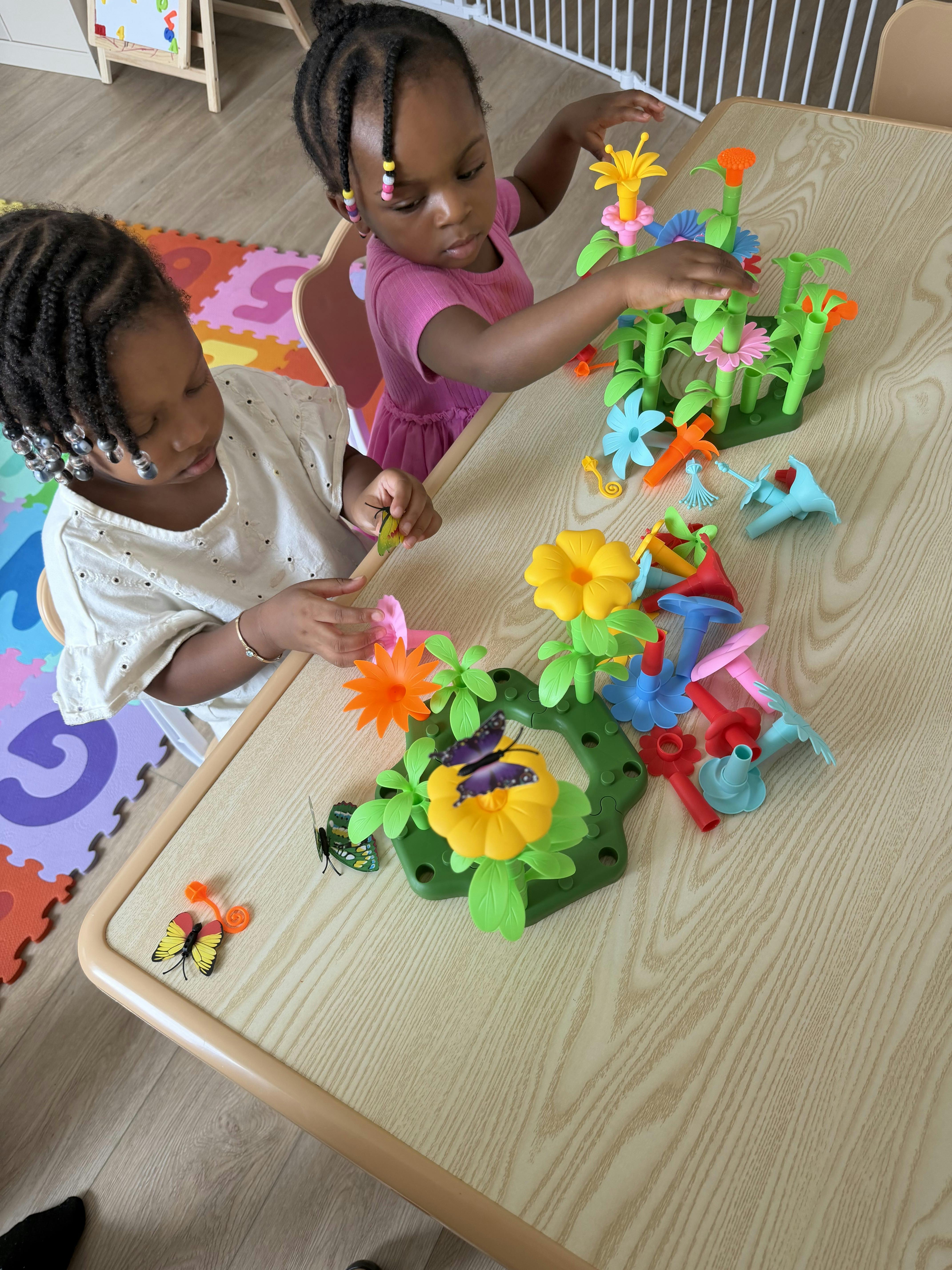 Two children playing with colorful plastic flower building toys at a table
