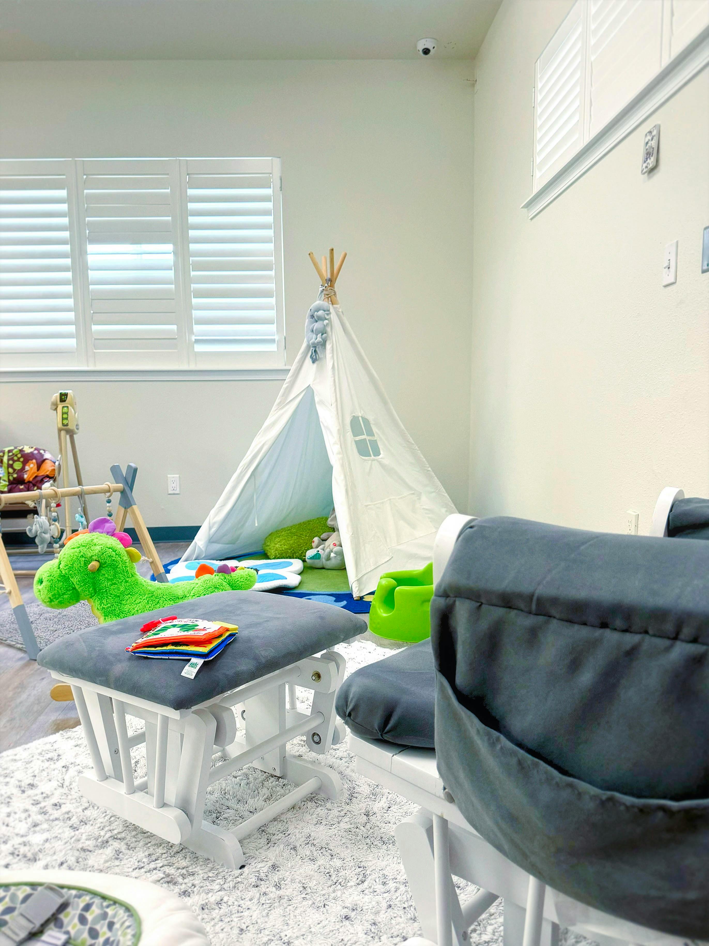 Playroom with a teepee, rocking chair, and toys