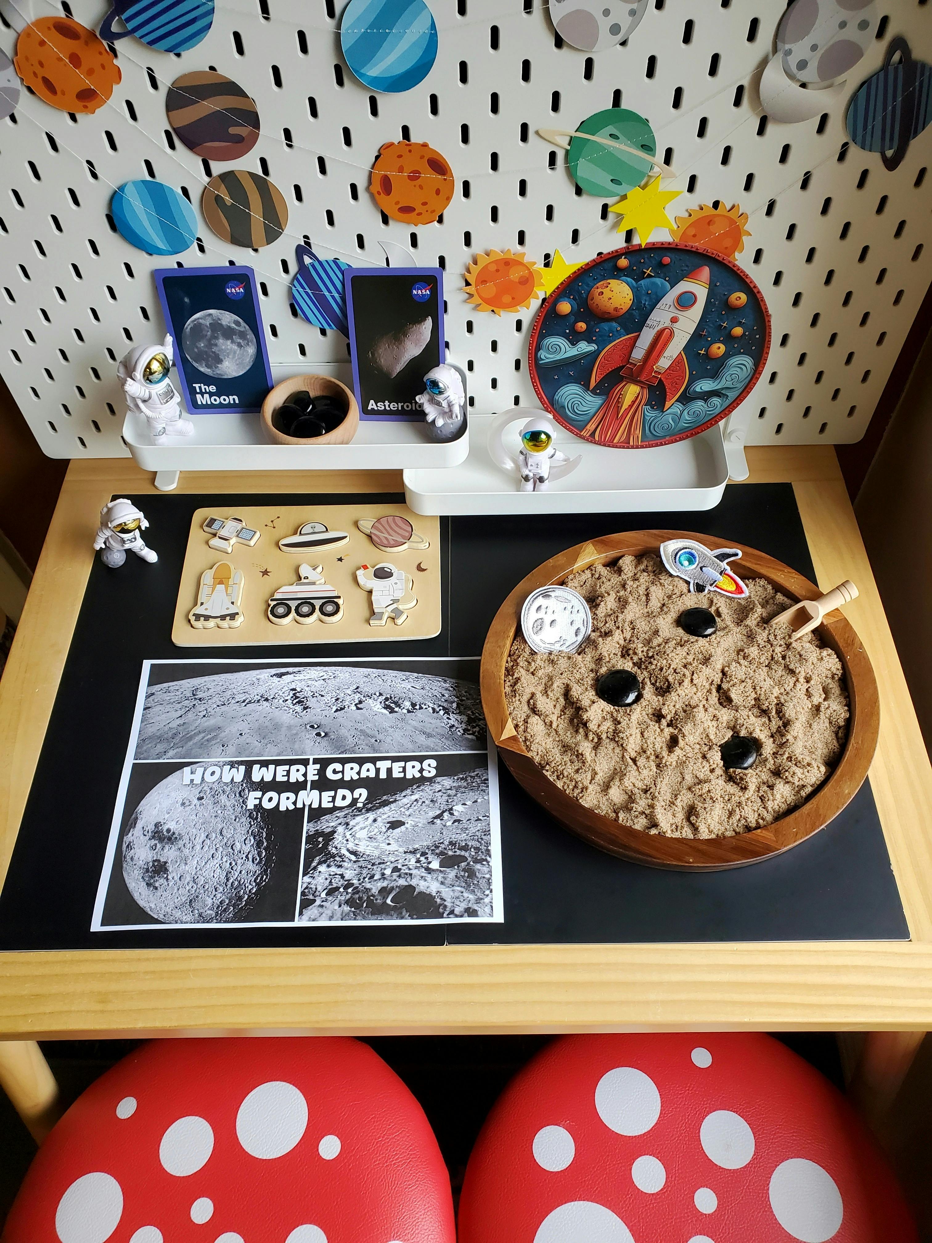 Space-themed display with a moon crater activity and astronaut figures