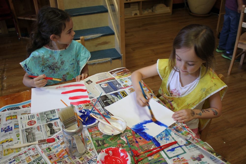 Two children painting at a table
