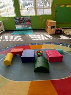 Soft play equipment on a colorful rug in a room
