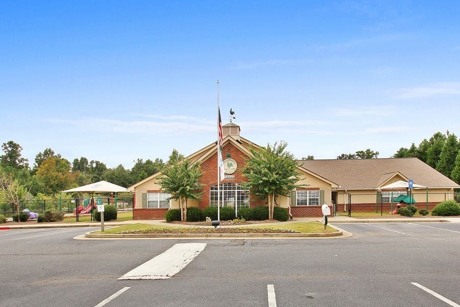 Building with a flagpole in front and a parking lot