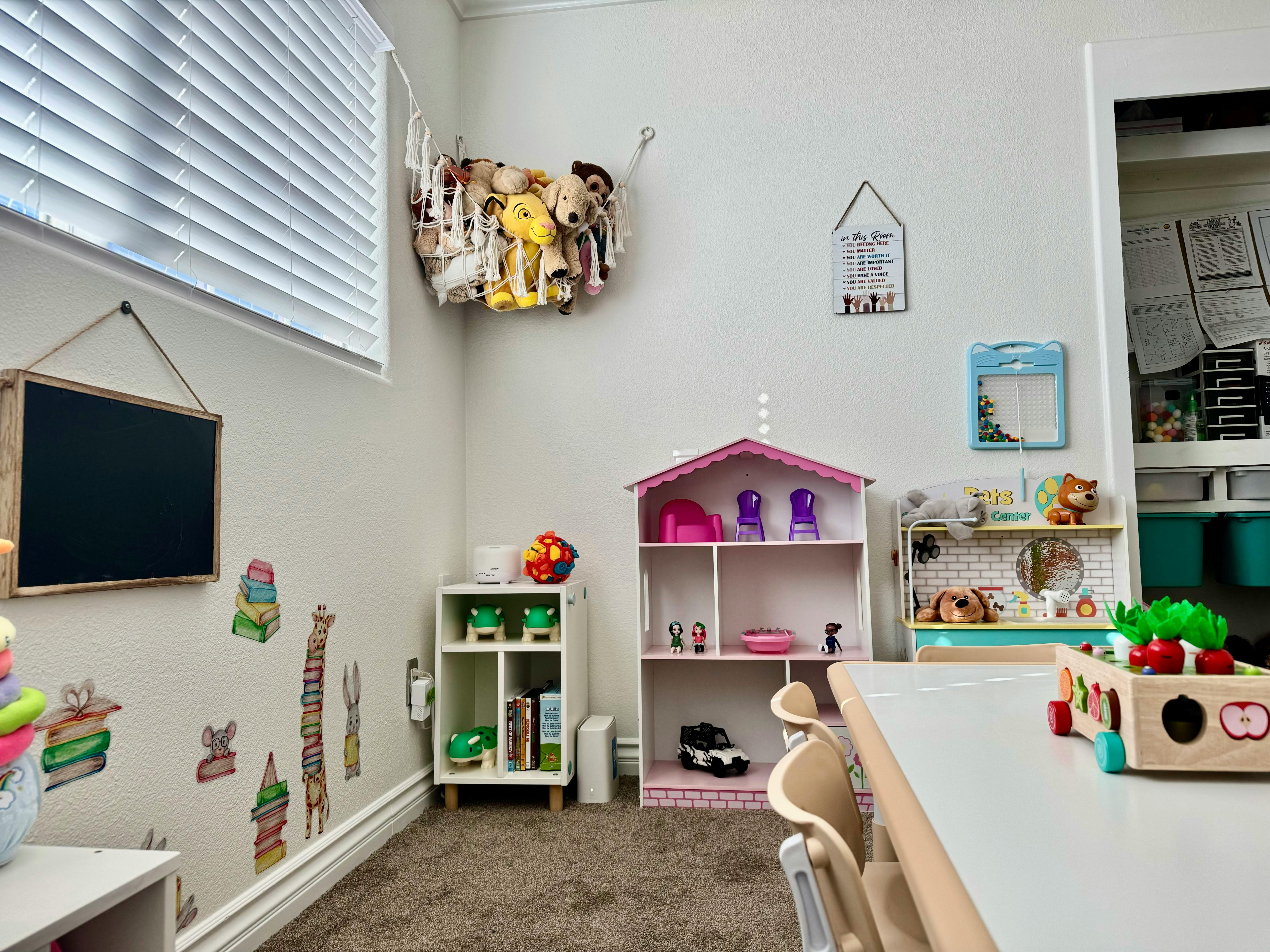 Playroom with a chalkboard, dollhouse, and toy kitchen