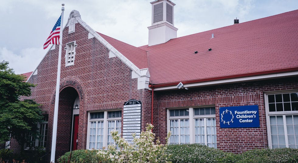 Brick building with red roof, American flag, and a sign for Fauntleroy Children's Center
