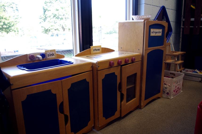 Children's play kitchen with sink, stove, and refrigerator