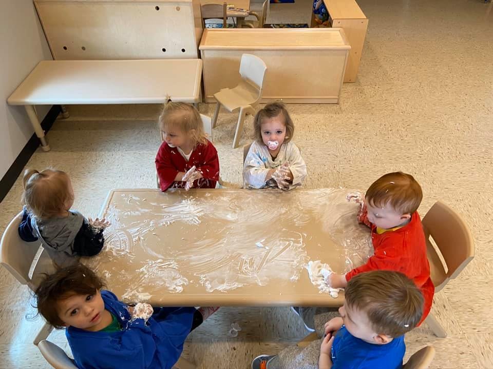 Children playing with flour at a table