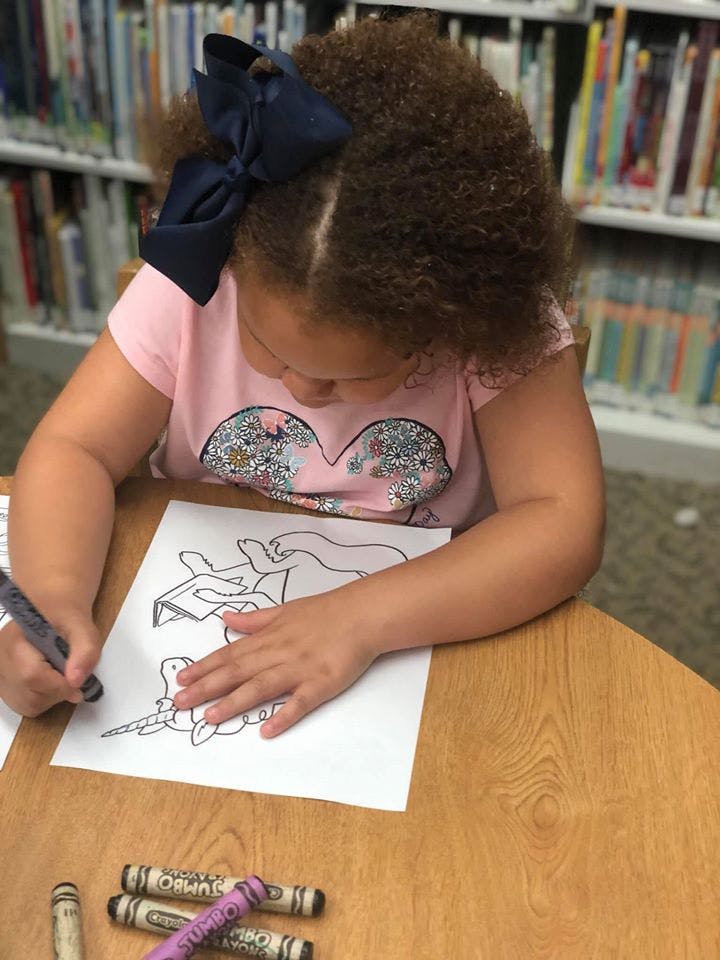 Child coloring a picture at a table