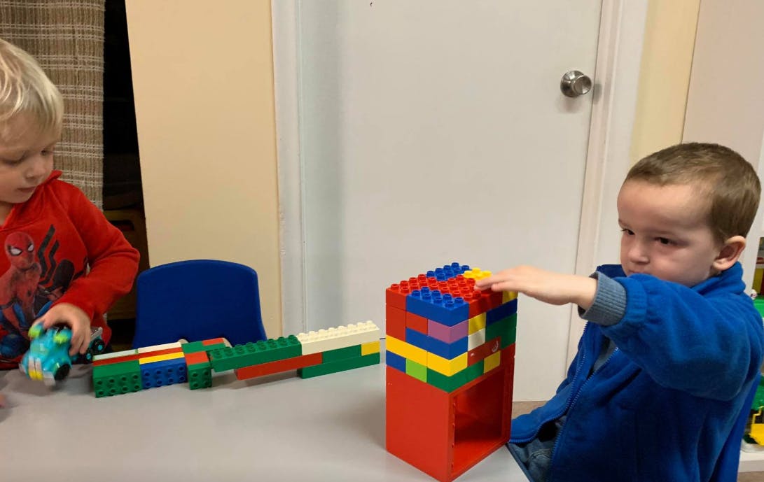 Two children playing with colorful building blocks