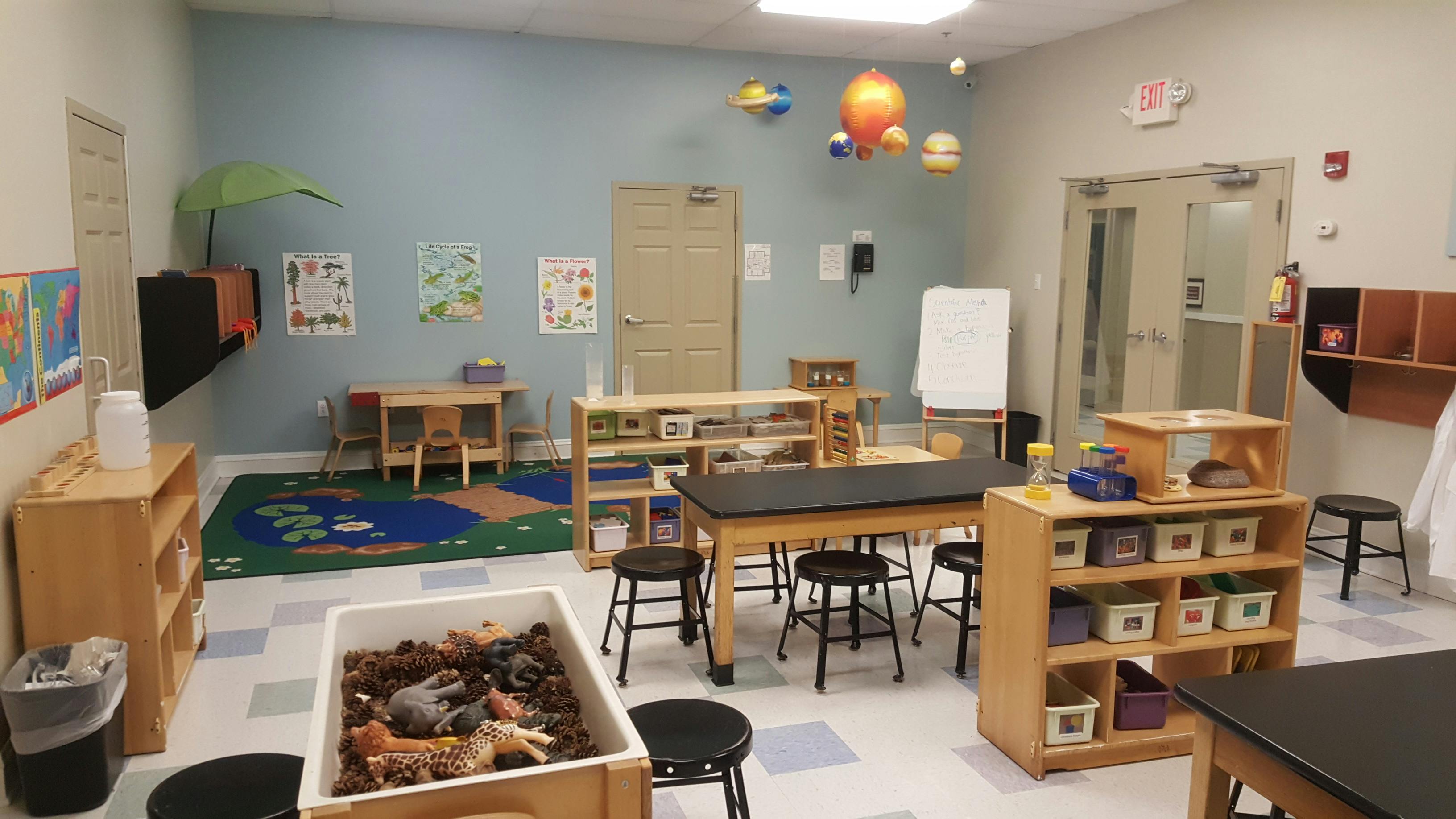 Classroom with tables, shelves, learning materials, and planet decorations