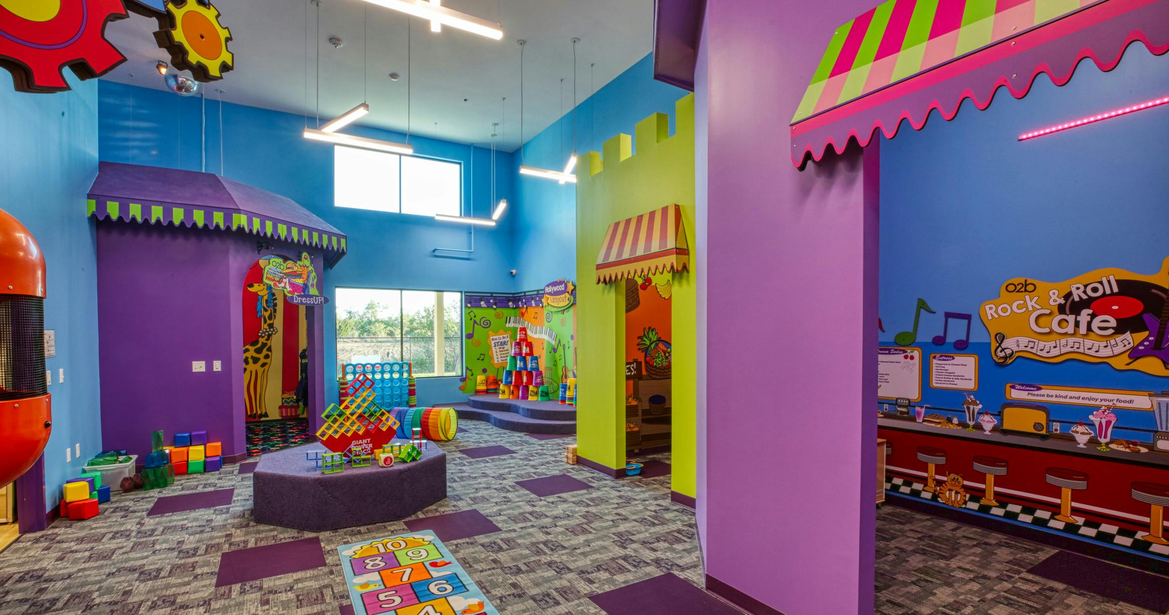 Colorful indoor playground with various play areas, including a Rock & Roll Cafe