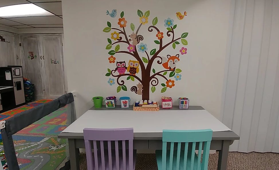 Table with two chairs and a tree mural on the wall