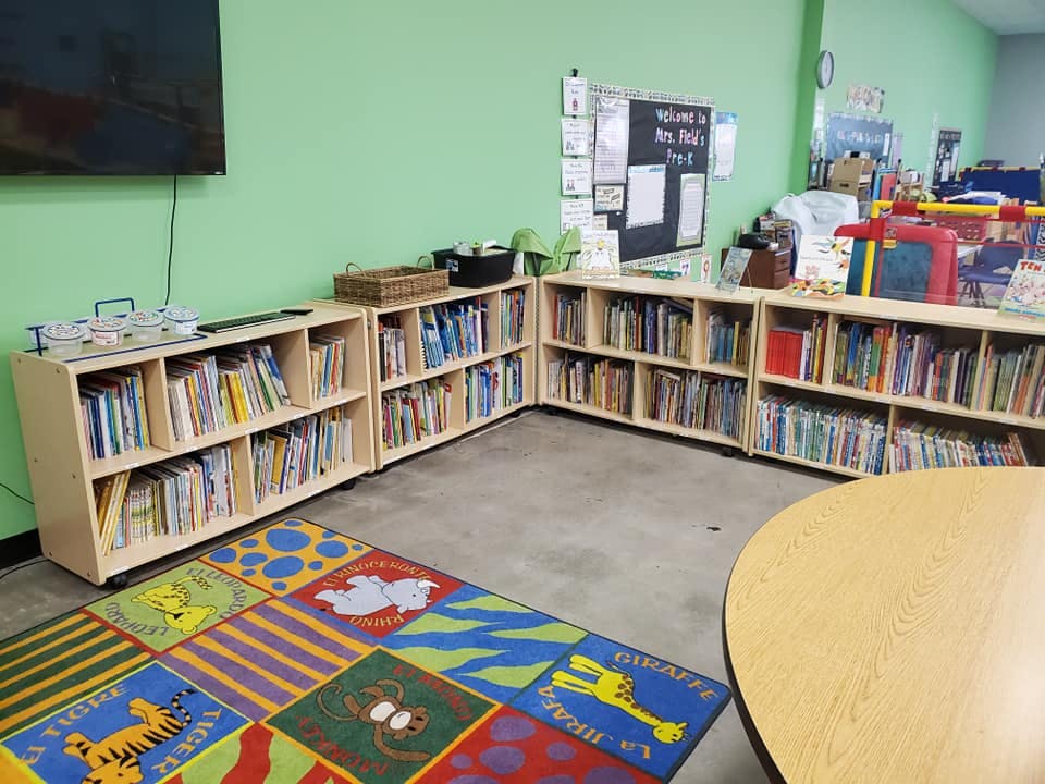 Classroom with bookshelves, a colorful rug, and a round table