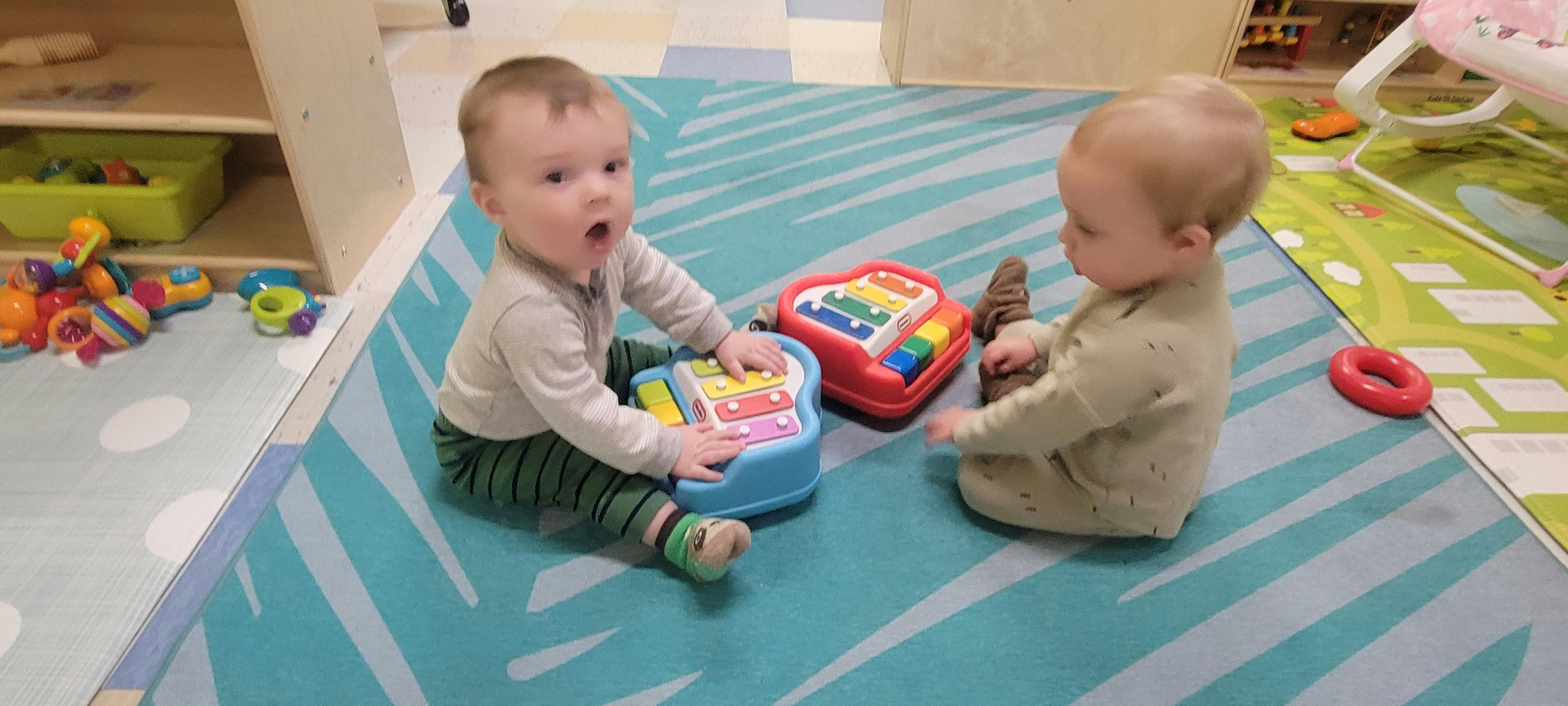 Two children playing with toys on a rug