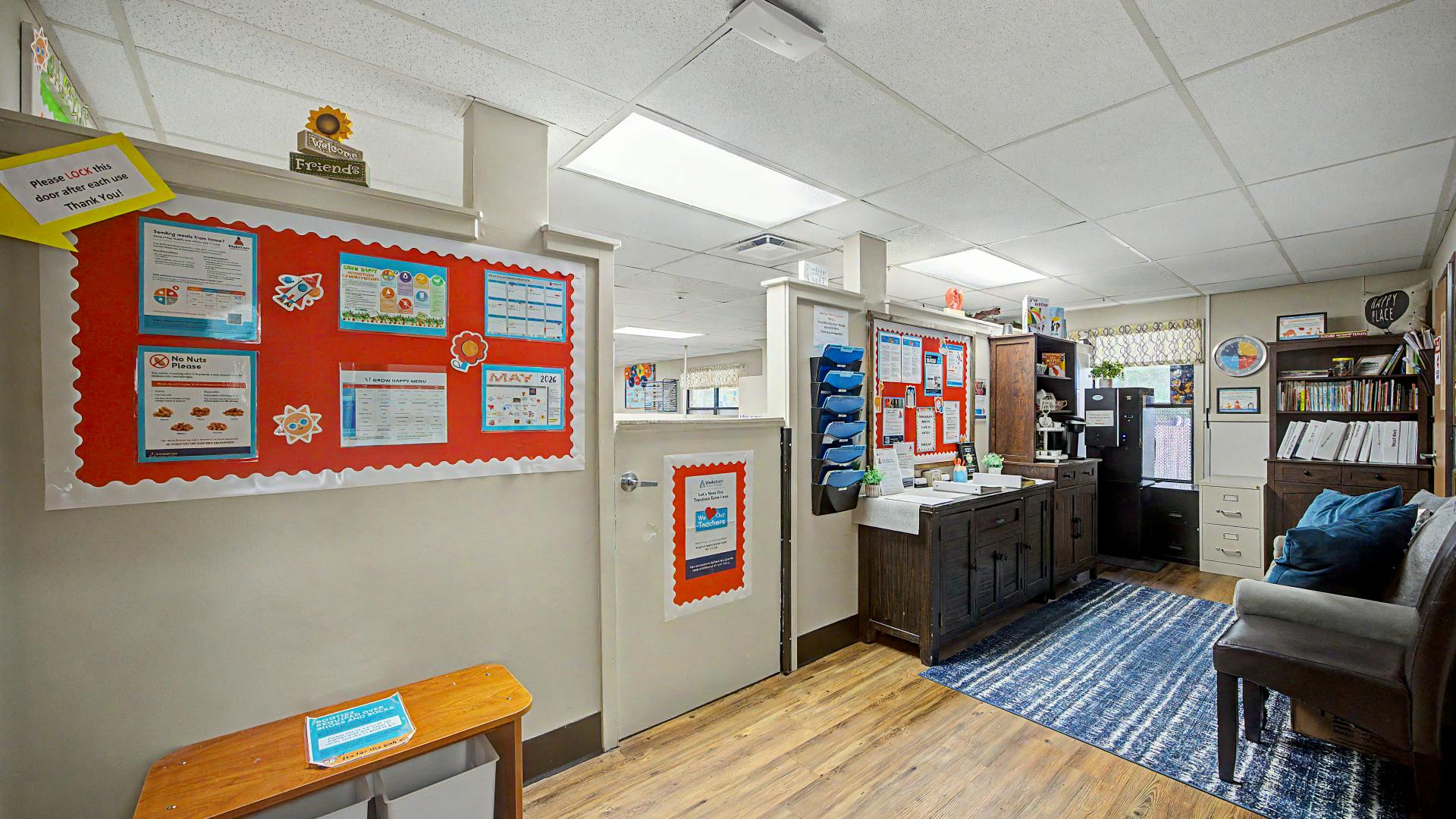 Lobby area with a bulletin board, wooden cabinets, and a blue rug