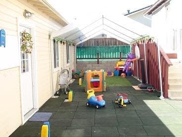 Outdoor play area with various colorful toys and a canopy